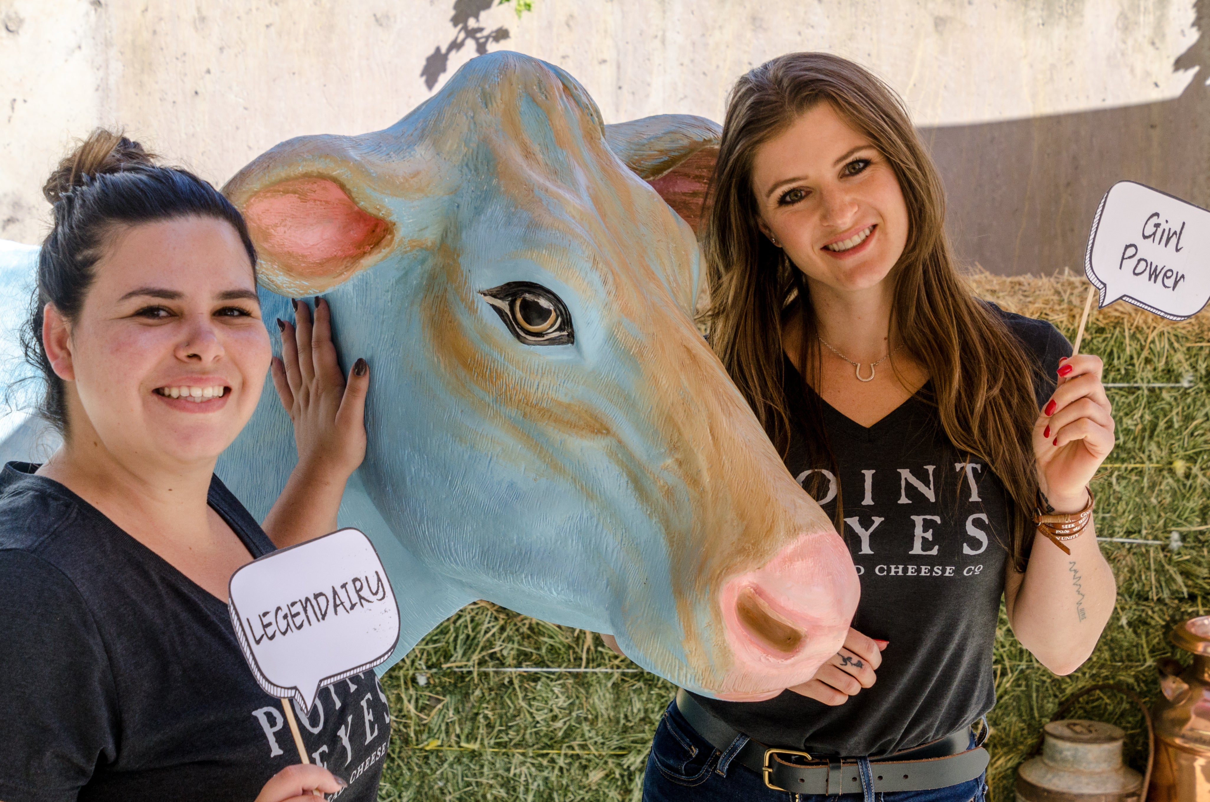 two employees with a cow statue