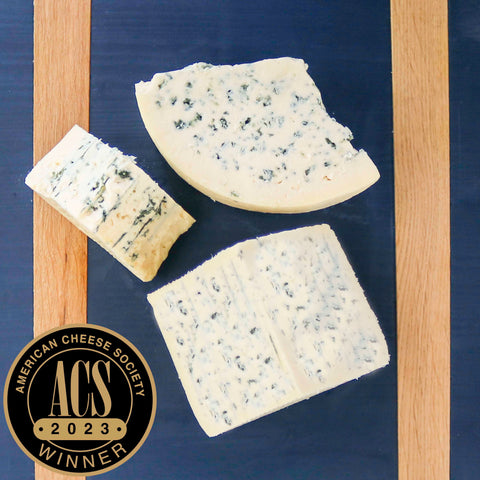 Product: original blue cheese on blue cheeseboard with american cheese society logo overlayed on the photo