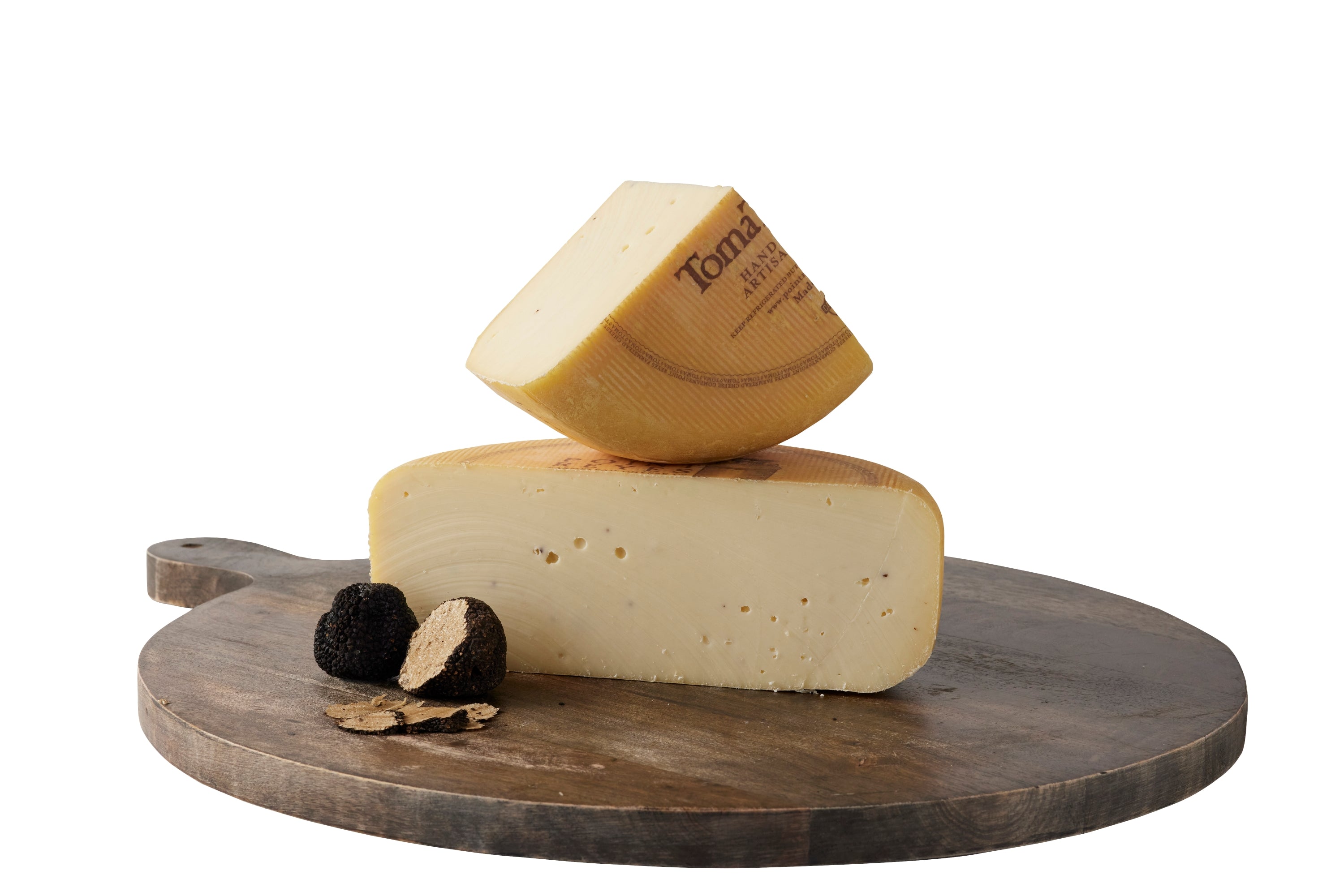 TomaTruffle cheese cut into pieces on a brown cheeseboard with two truffles