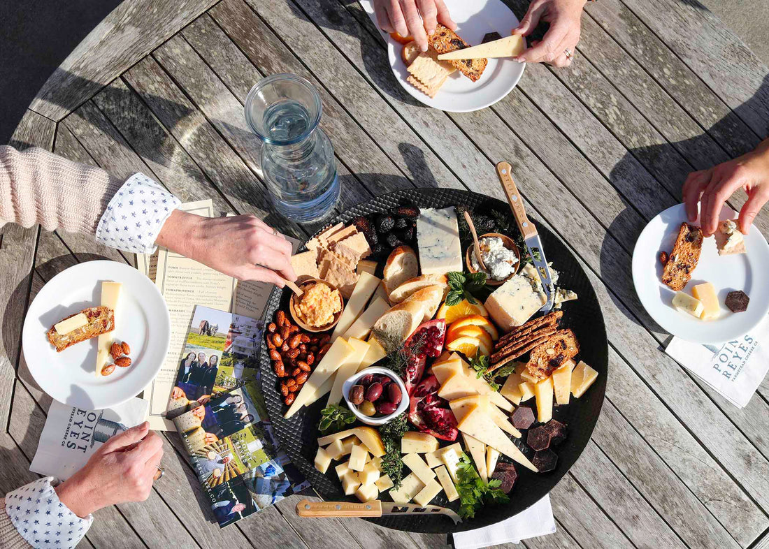 Hands reaching for a cheeseboard