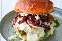 Big burger with blue cheese fondue and balsamic onions on a bun