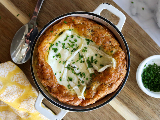 baked eggs in a ceramic pot with cheese and chives