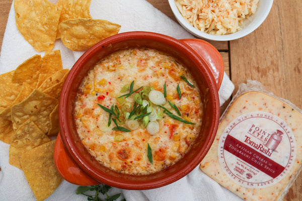 hot corn dip in red cast iron with chips