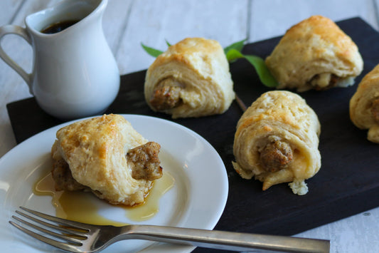 breakfast sausage wrapped in biscuit with maple syrup