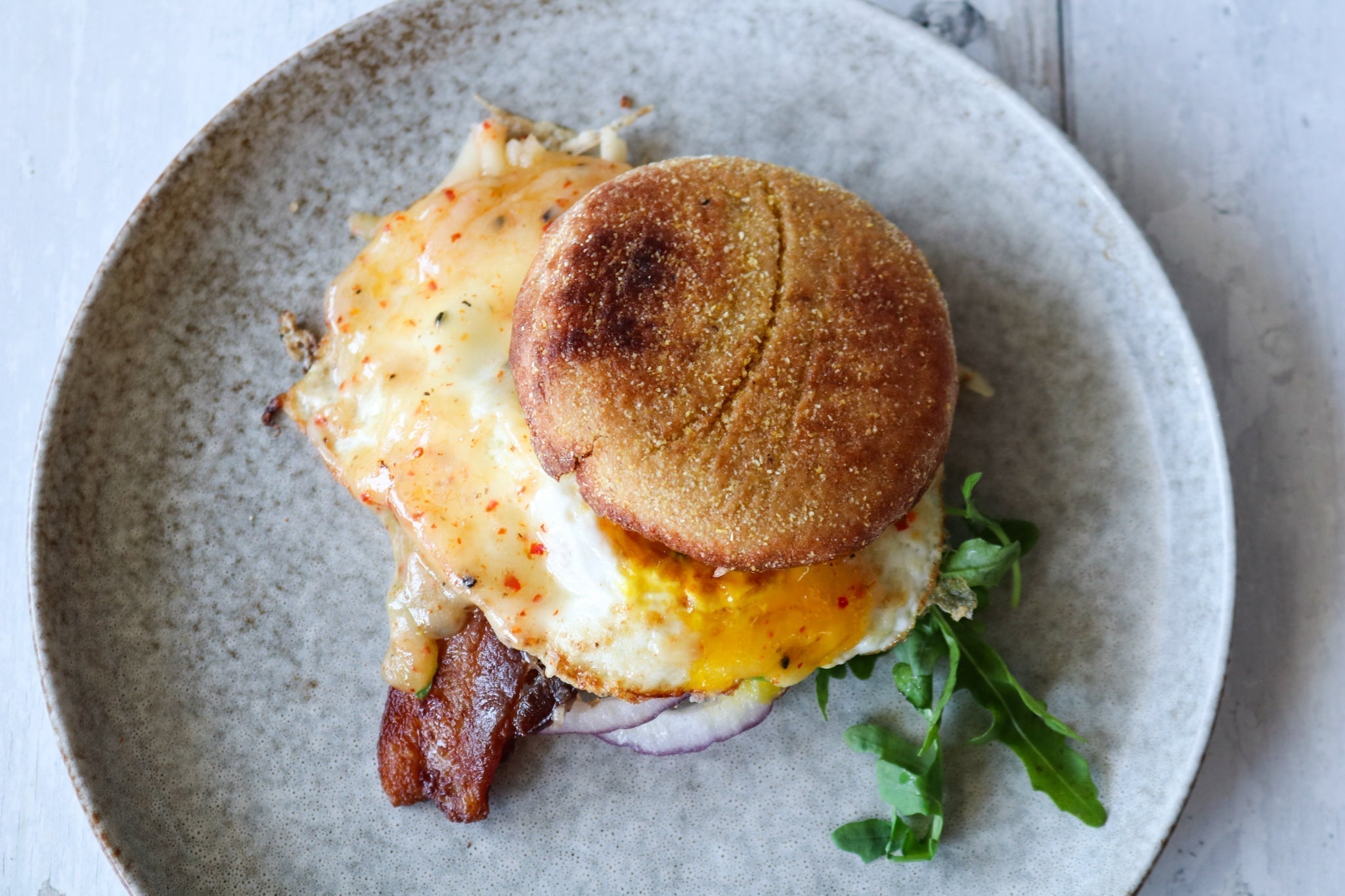 Breakfast sandwich on english muffle with egg and cheese on a plate