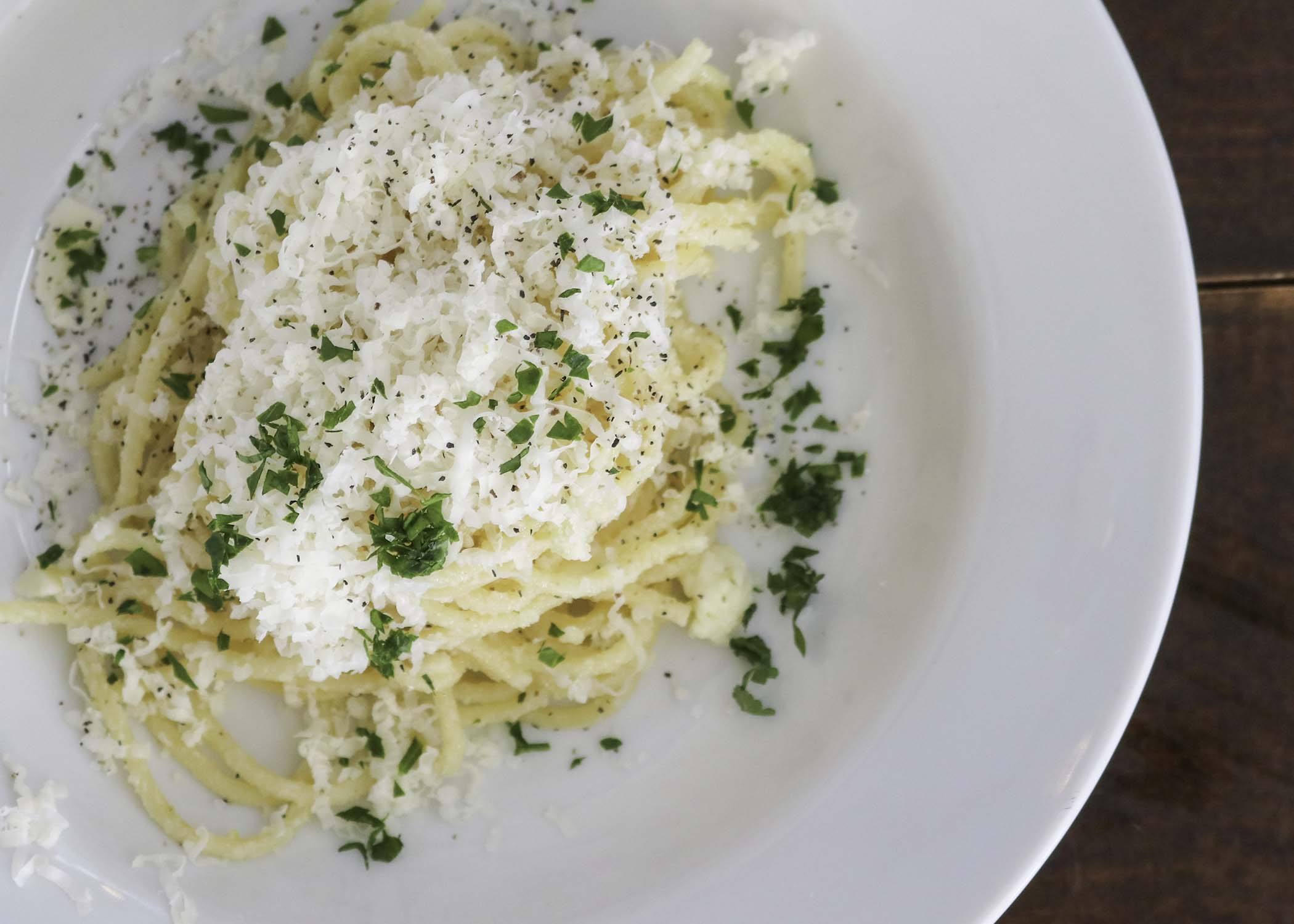 Cheesy TomaTruffle pasta with shredded cheese and parsley on top