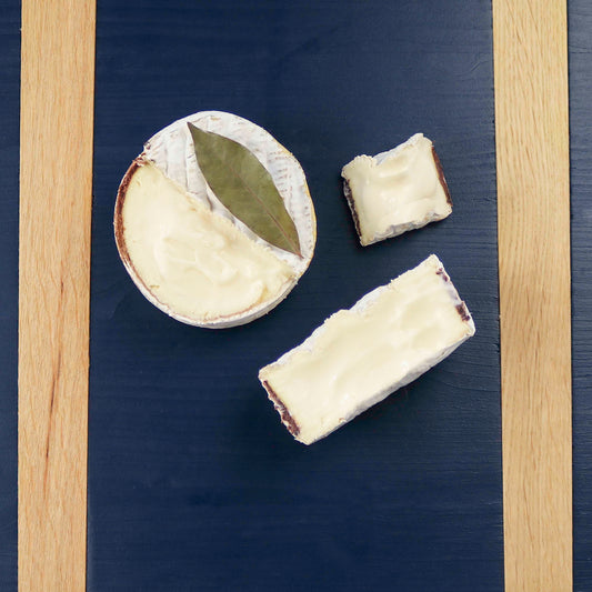 Cut wheels of Quinta cheese on a blue cheeseboard
