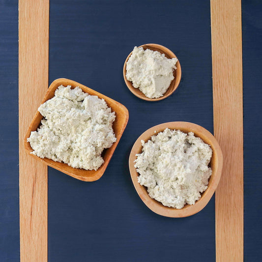 Original Blue cheese date spread in three wooden bowls on a blue board