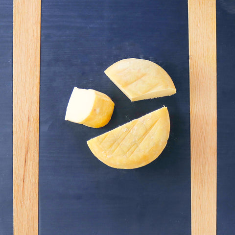 Product: Cornelia cheese cut into pieces on a blue cheeseboard